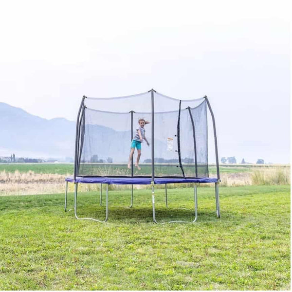 A child jumping on a traditional spring-based trampoline.