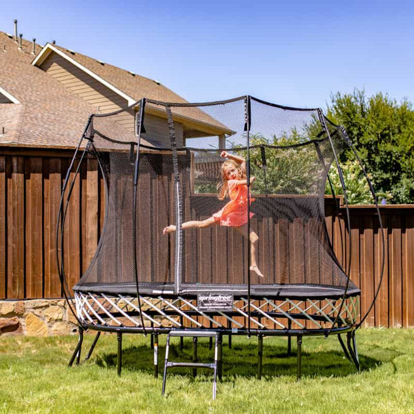 Girl jumping on a Springfree Oval Trampoline.