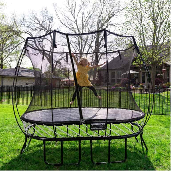 A little girl jumping on a springless trampoline.