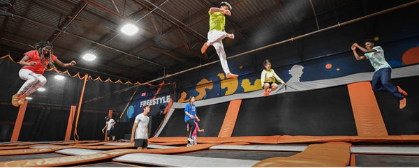 Multiple people jumping in mid-air at a trampoline park.