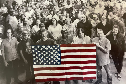 STI Plant workers holding an American Flag