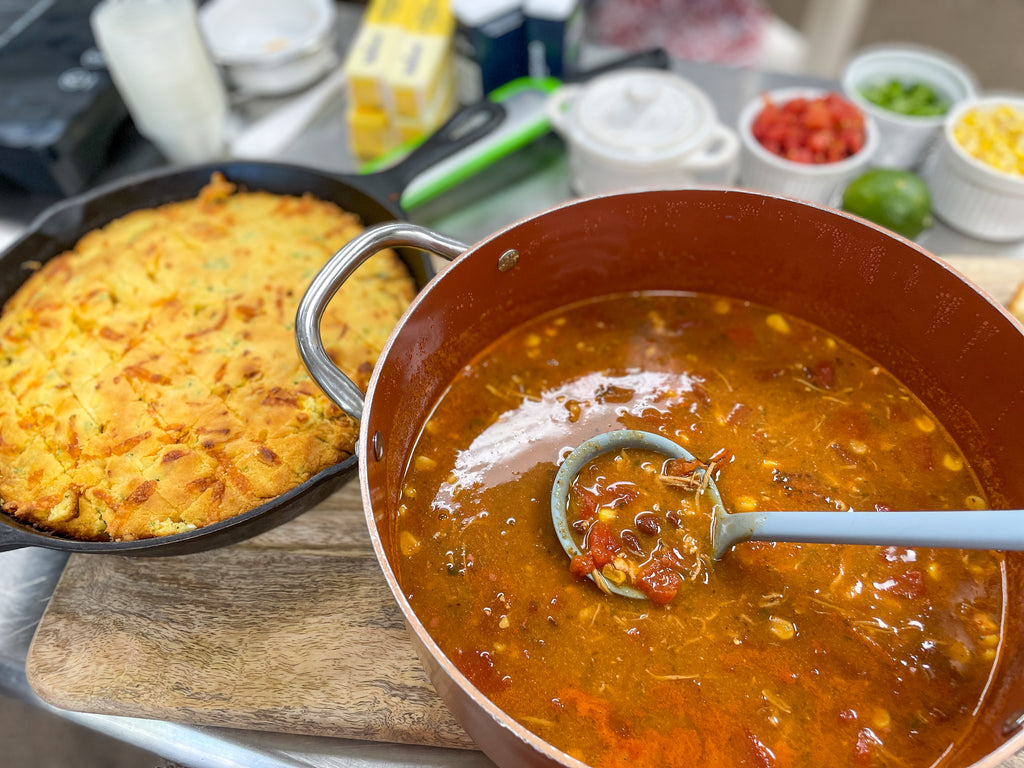 a pot of chicken tortilla soup and a loaf of jalapeno cheddar bread on a charcuterie board