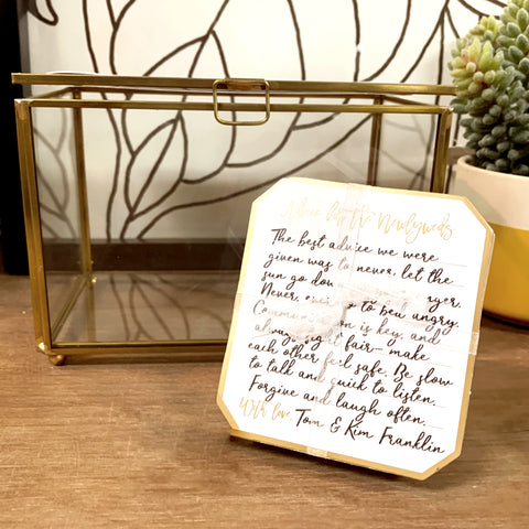 photo of a keepsake glass box with gold metal frame and a written note.