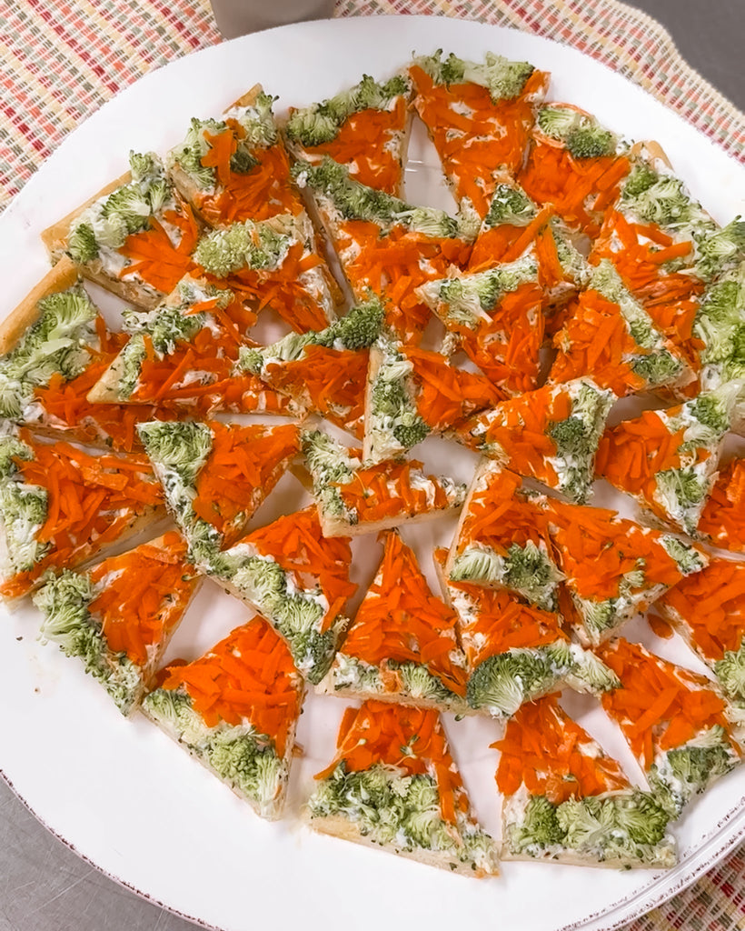 a platter of spinach fiesta veggie pizza bites with carrots and broccoli