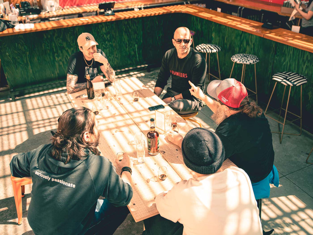 The Hawkers crew sitting, talking and trying beers at a table with Eric from Evil Twin