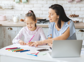 mother and daughter seated next to one another working on homework