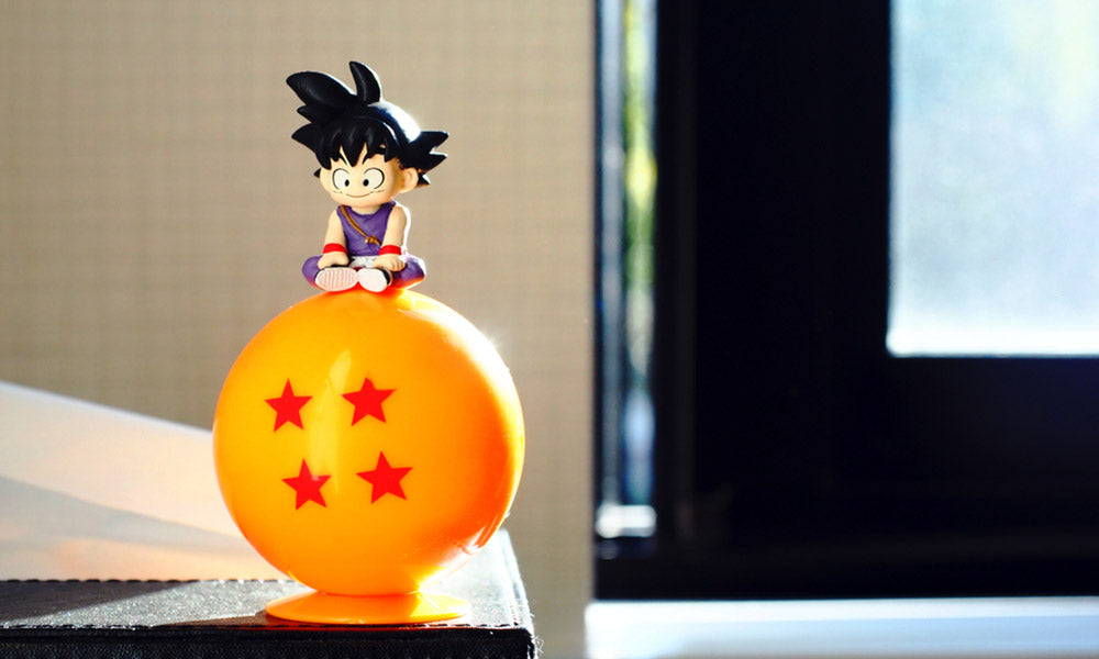 Un gashapon dragon ball avec la figurine de sangoku et une boule de cristale à quatre étoiles