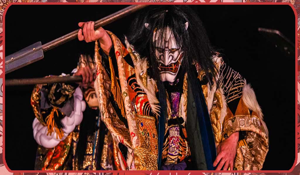 A man in Japanese theater kagura wearing a white oni mask and a traditional kimono