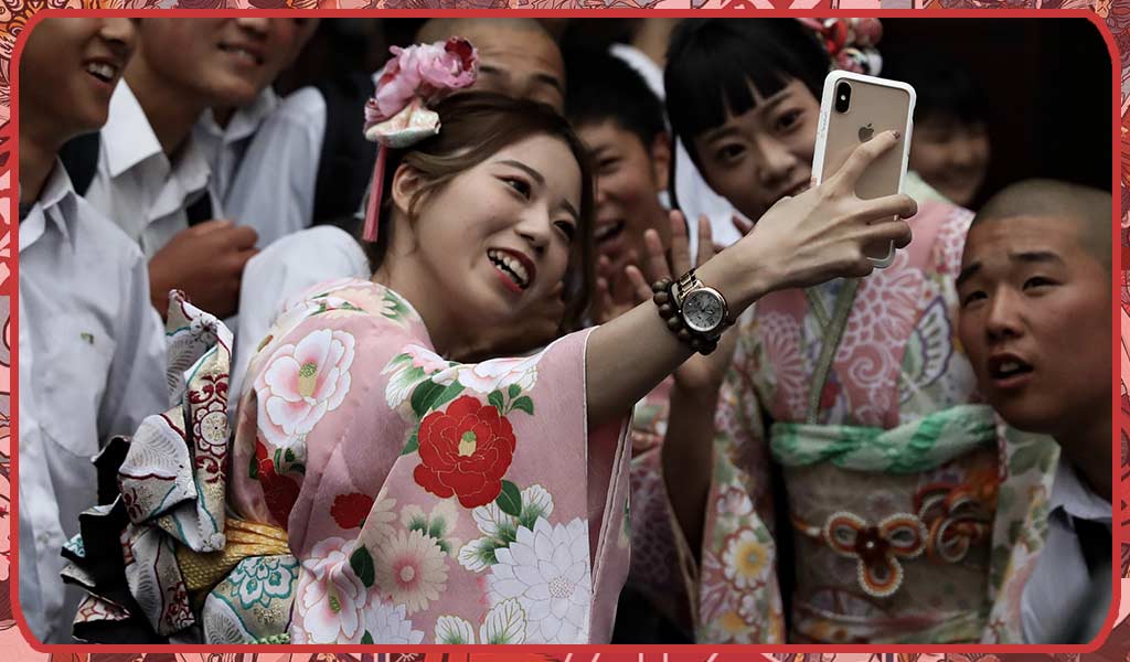 une femme célébrant le jour des adultes Seiji No hi en prenant une photo avec ses amis garçons