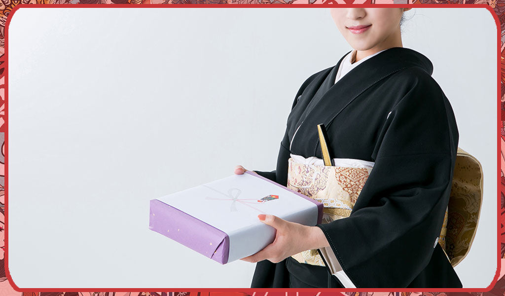 Femme portant un kimono tomesode noir avec une ceinture obi dorée