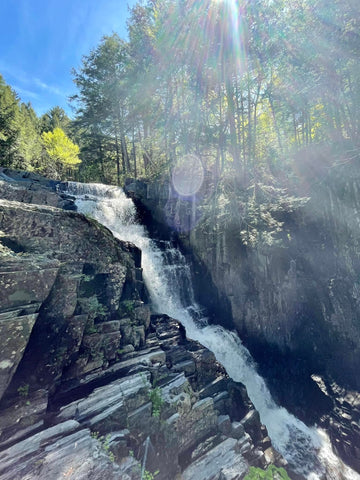 Waterfall cascading over slate rocks with trees above