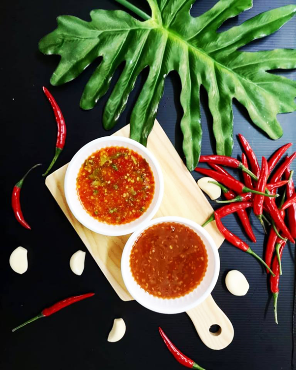 Professionally done shot of 888 Mookata's Chilli with chilli pieces and a black background
