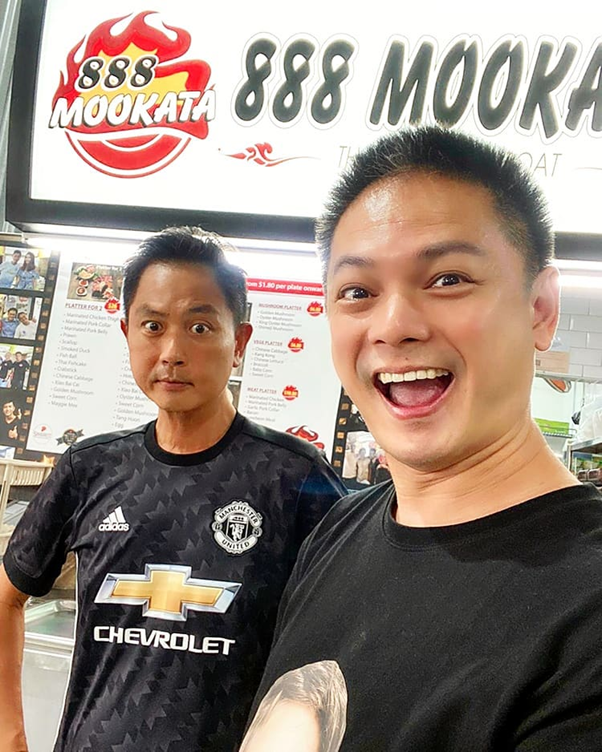 Mediacorp artistes Chor Chew Meng and Dennis Chew posing in front of their store, 888 Mookata