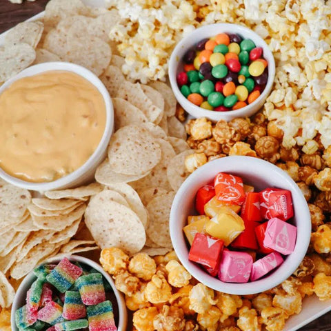 Popcorn Charcuterie Board filled with popular snacks like sweets and potato chips