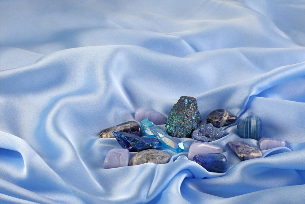 collection of stones including sodalite on blue silk