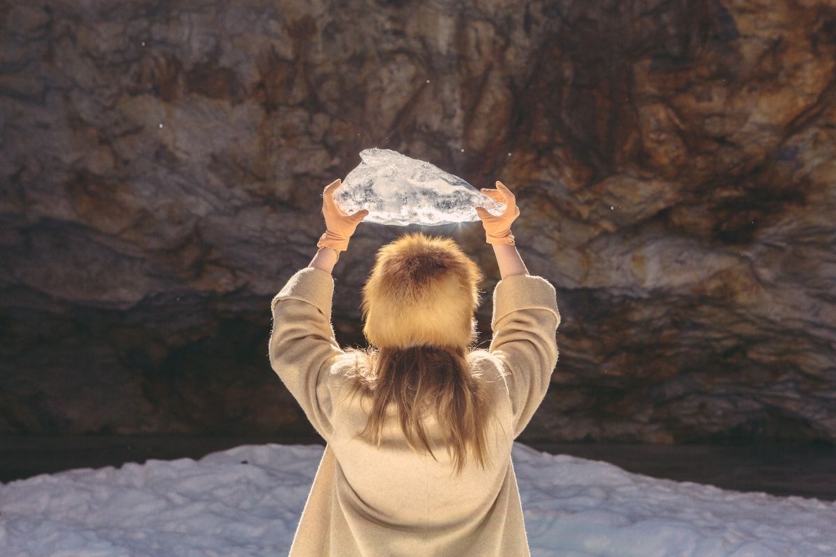 femme avec un gros quartz au-dessus de sa tête dans la neige