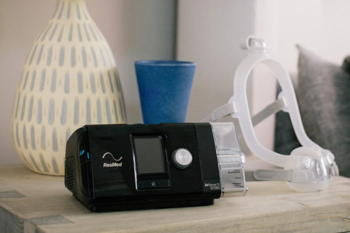 The ResMed AirSense 10 AutoSet sits on a bedside nightstand. The AirSense was among the best CPAP machines to buy in 2022.