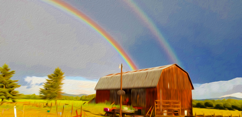Old red wooden barn with double rainbow