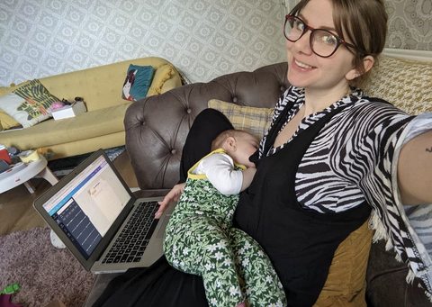 mum-breastfeeding-on-sofa-with-laptop-on-knee-dungaree-doula