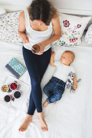 breastfeeding mum in bed with snacks