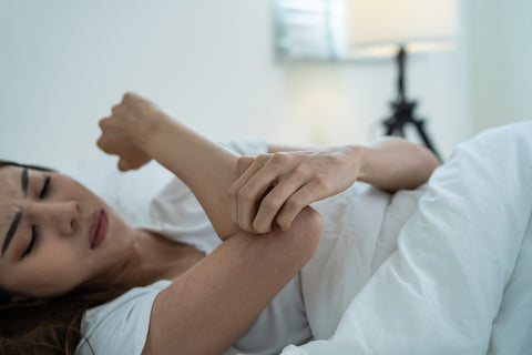 Asian young woman scratching hand while sleeping.