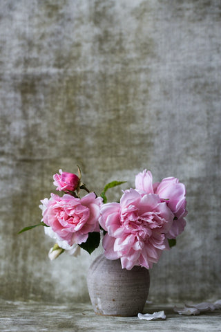 A bunch of pink peonies in a green vase