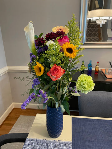 Sunflowers in a mixed arrangement and placed in a 10” Amaranth Vase in Blue