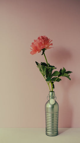 A signle flower in a metallic bottle/vase