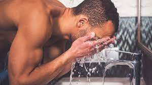 man washing face naked