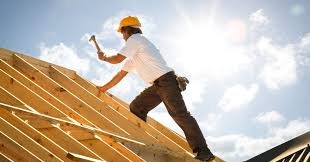 man working on roof trusses in the sun