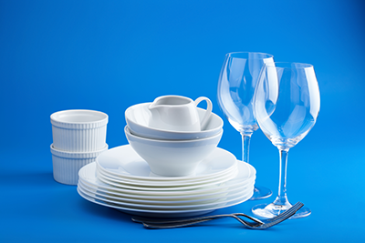 Clean and Sanitized Dishware - Plates and Glasses with a Blue Background