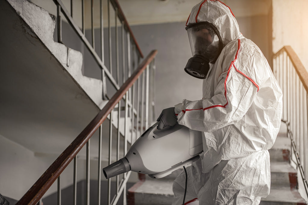 Man in white protective suit in the hotel sprays rooms with a mosquito fogger. Invatech Italia