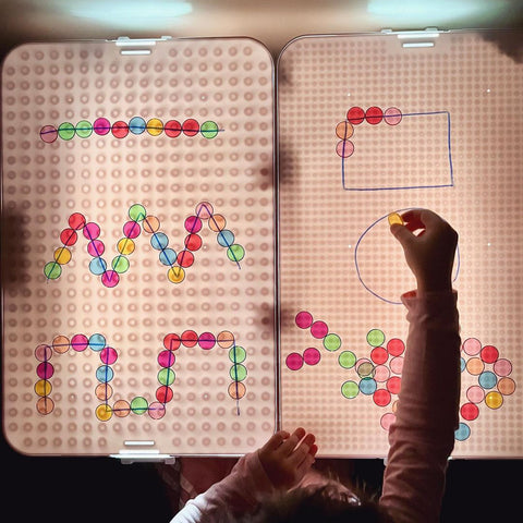 White Carry-Play light table with magnetic chips and marker drawings