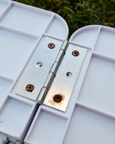 Rusy metal hinges and screws on the Carry-Play kids table