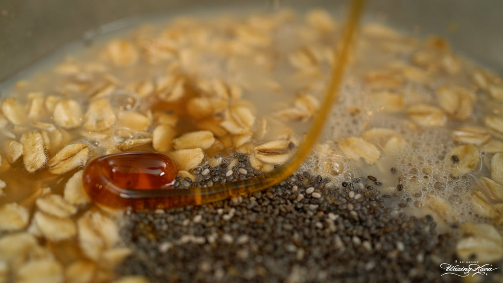 Honey drizzling into a bowl of oats and seeds