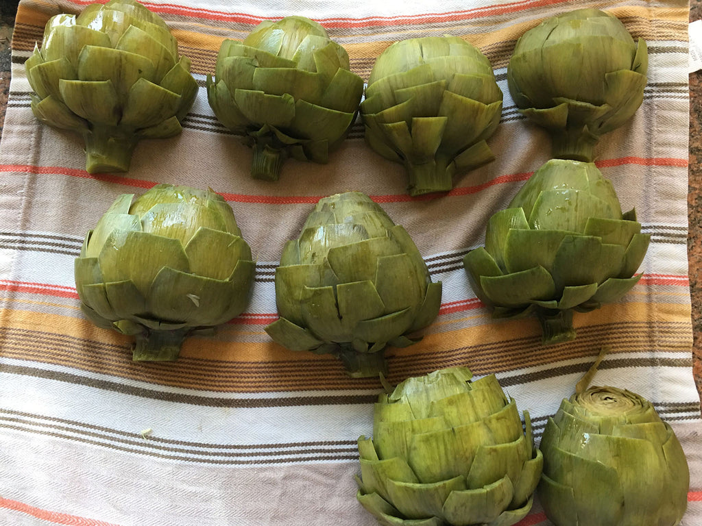 Artichokes on a tray before grilling