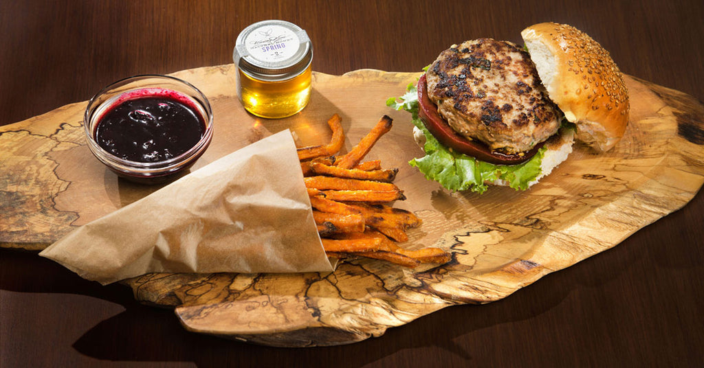 Feta turkey burger next to sweet potato fries and blueberry ketchup