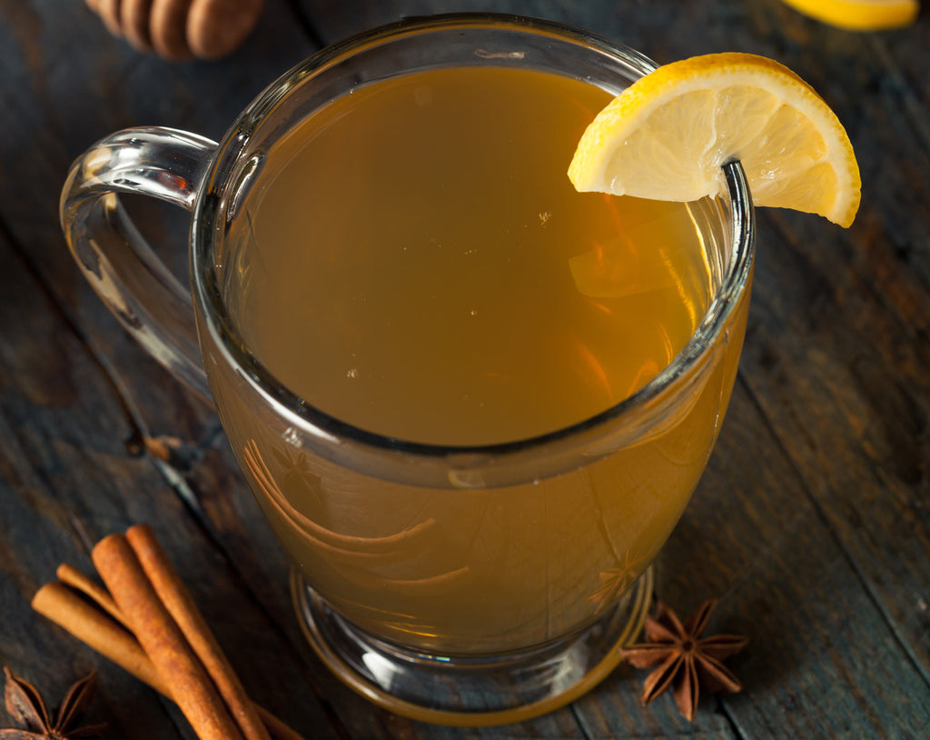 Hot toddy in a glass tea cup with a lemon slice as garnish