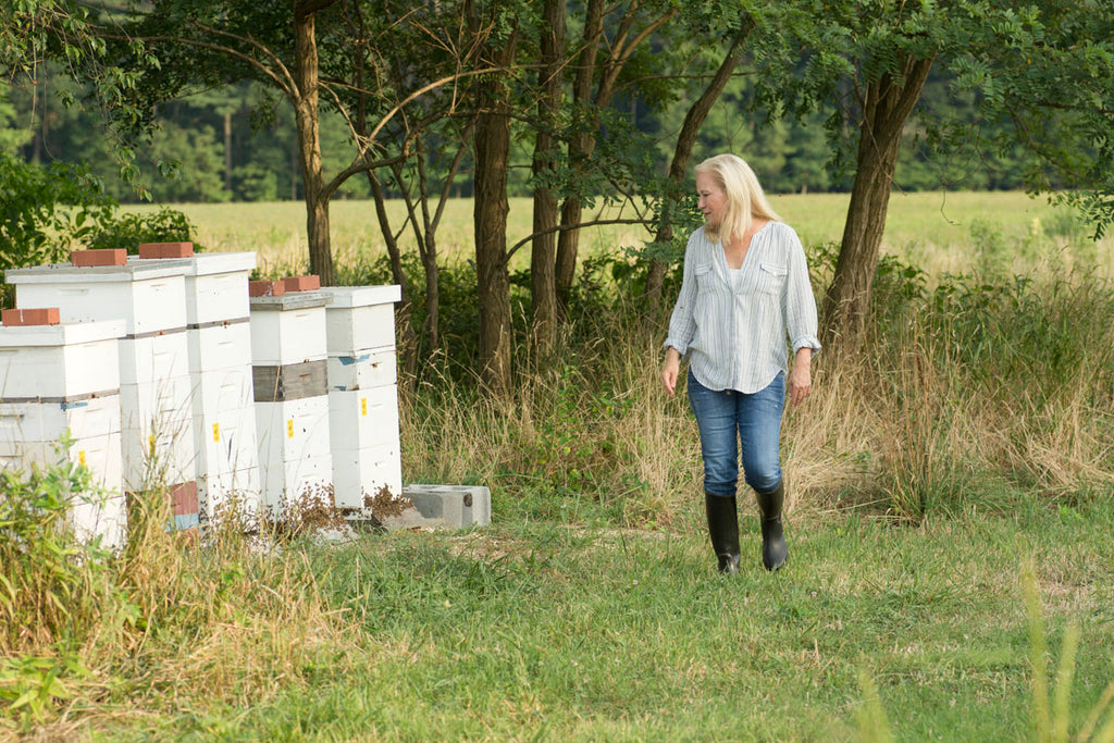 Kara walking in a field next to her hives