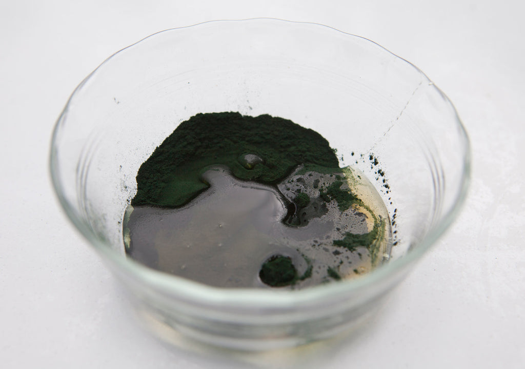 Spirulina face mask in a small glass bowl