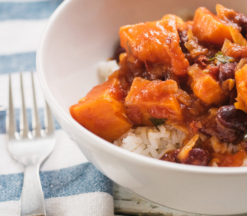 Sweet potato chili in a white bowl next to a silver fork