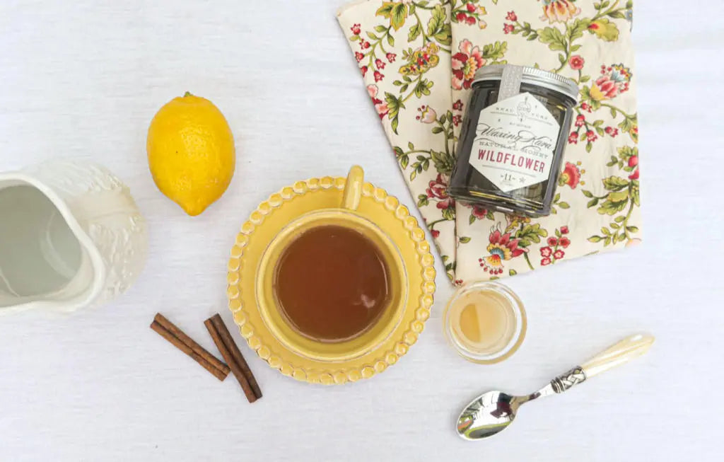 Apple Cider vinegar tea with cinnamon stick floral napkin Bee Inspired wildflower honey lemon and spoon