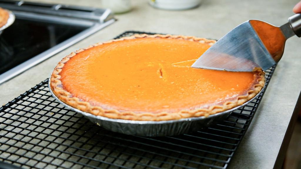 cutting pumpkin pie on cooling rack