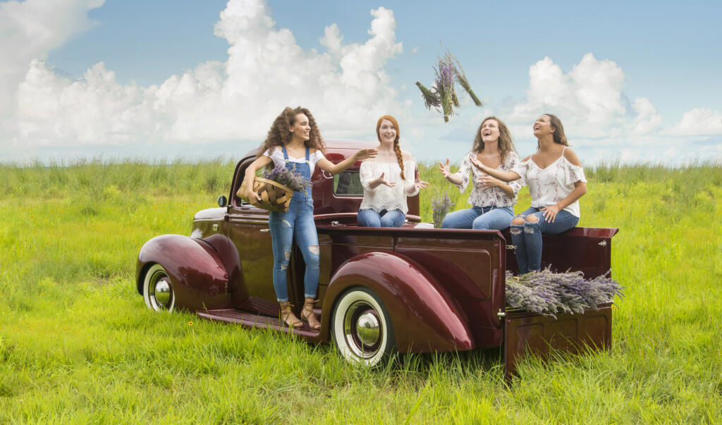 old red truck with girls frolicking in field