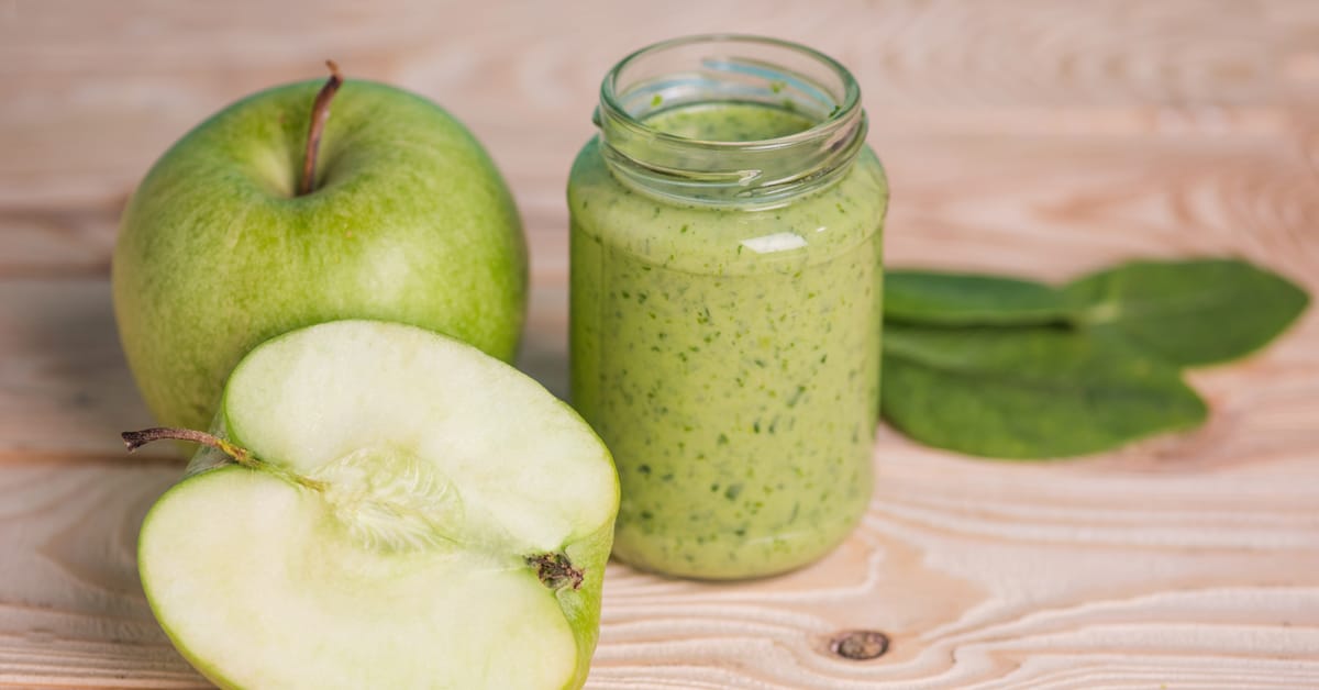 green smoothie made with green apple and spinach in mason jar on table