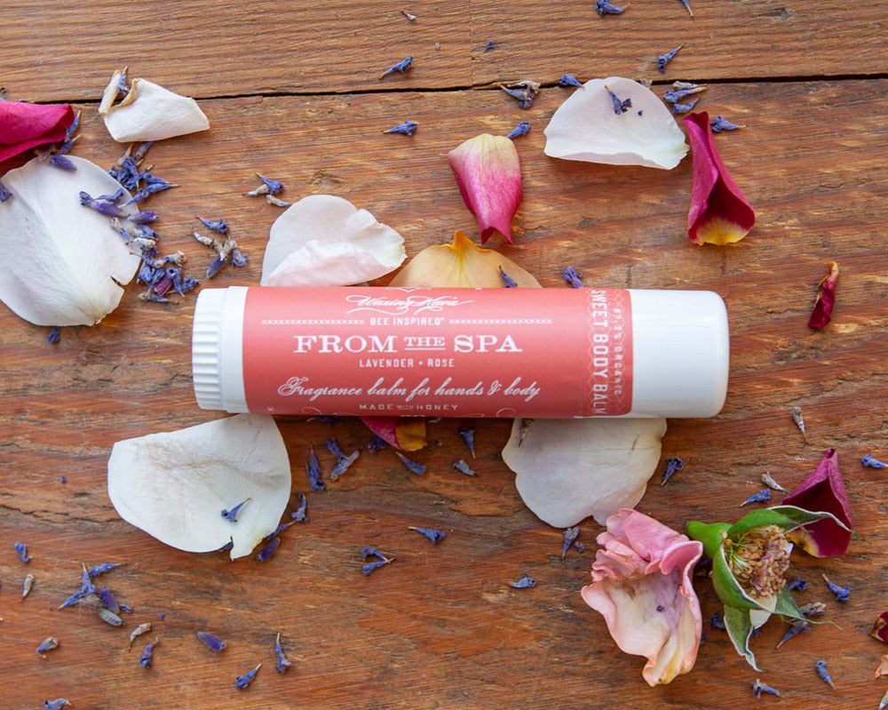 From the Spa Fragrance Balm for Hands and Body with rose petals and lavender flowers on red wood table