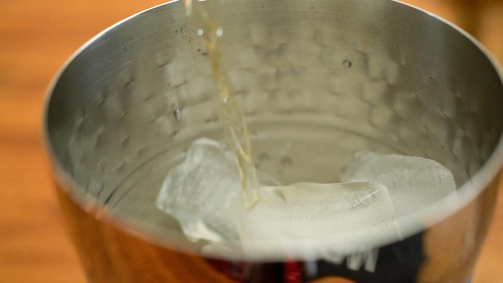 adding bourbon to shaker for honey and bourbon drink