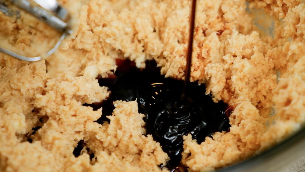 mixing molasses into gingerbread cookie dough