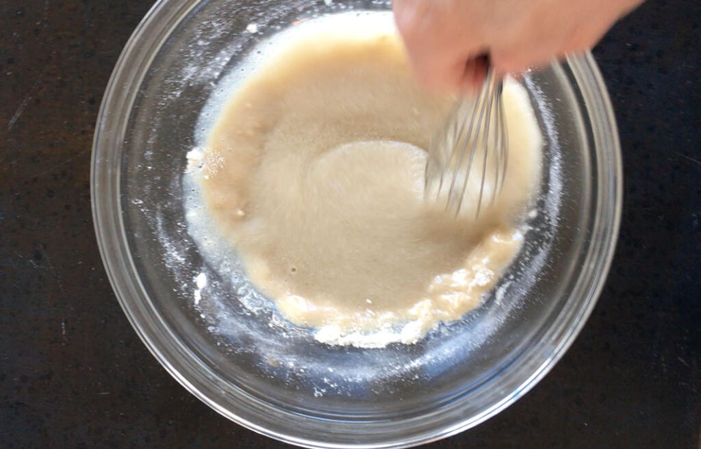 mixing honey oat scrub with whisk in glass bowl on black counter