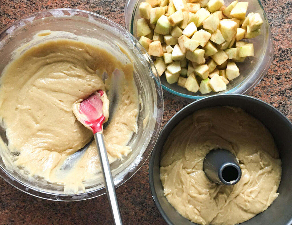 Making jewish apple cake with chopped apple, batter and spring form pan